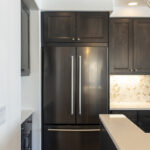 The large double door fridge with cabinets between the top of the fridge & the ceiling.