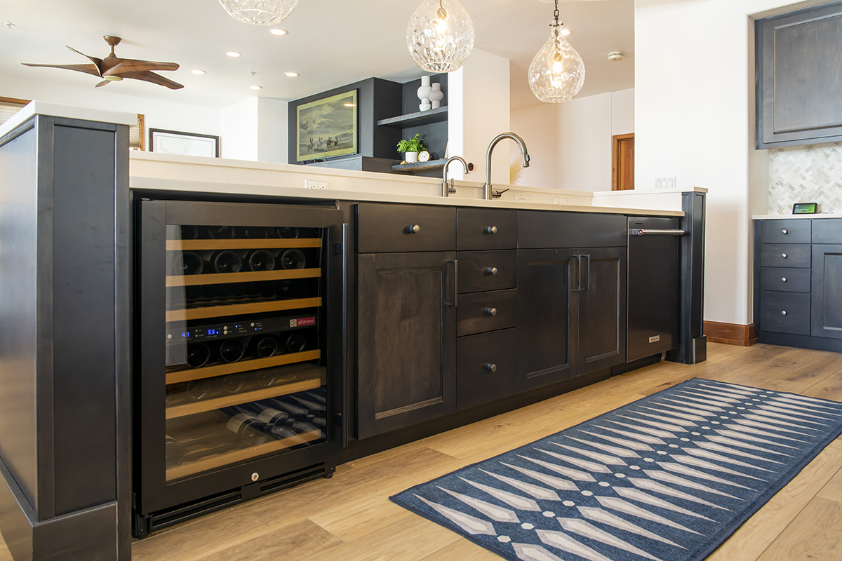Looking at the cabinets that make up the island. There is a wine cooler on the left hand side, a combination of 3 doors and 5 drawers make up the middle of the island with the dishwasher being on the right end.