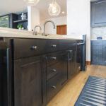 A view of the cabinet doors and drawers with brushed grey hardware on the island.