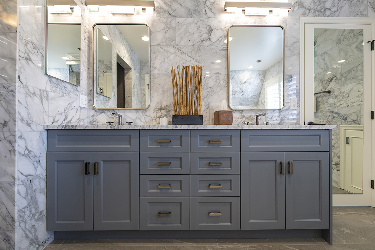 gray bathroom cabinetry with dual sink, multicolored stone vanity