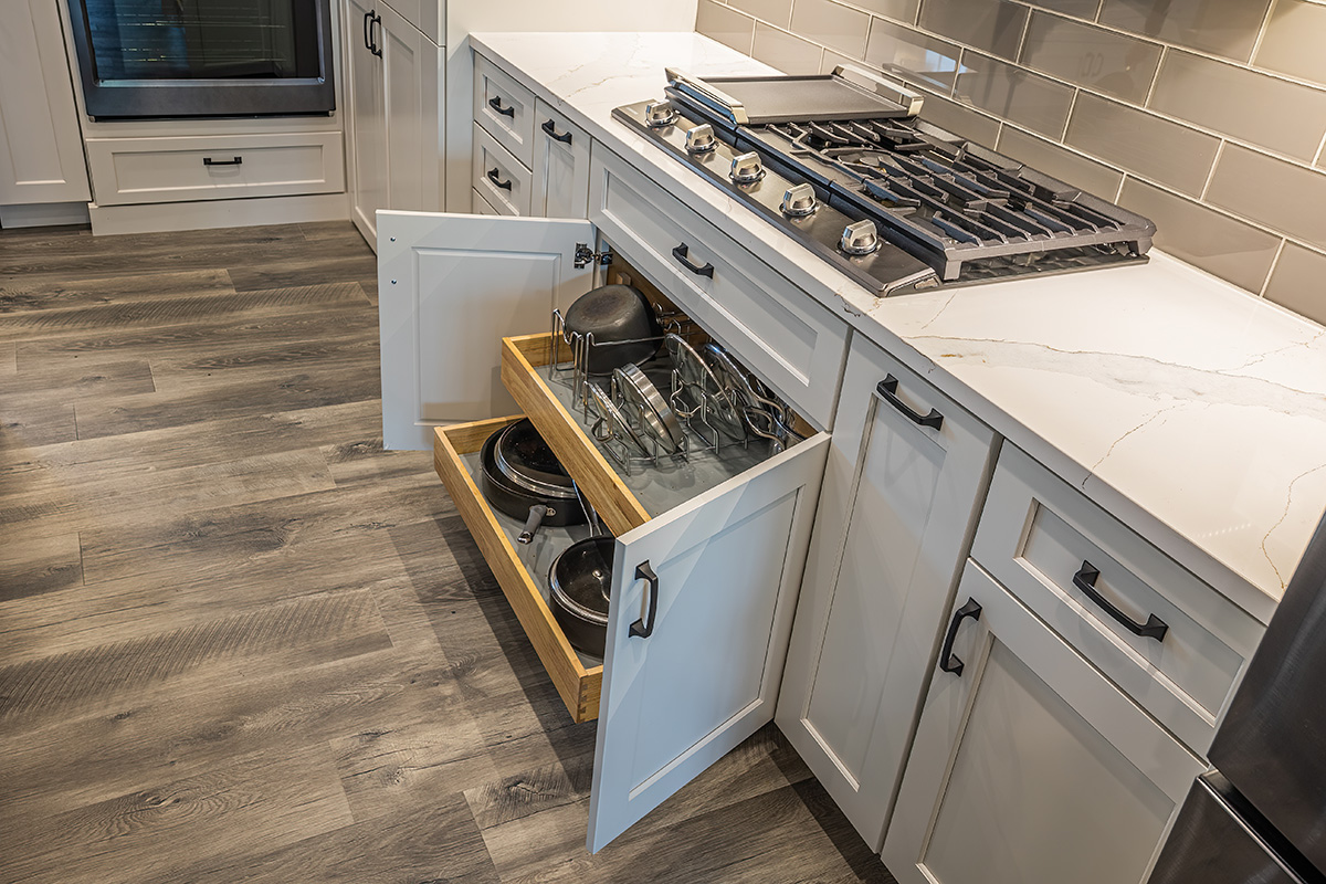 white kitchen cabinets, pot and pan drawer under stove