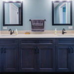 dual sink bathroom with dark cabinets