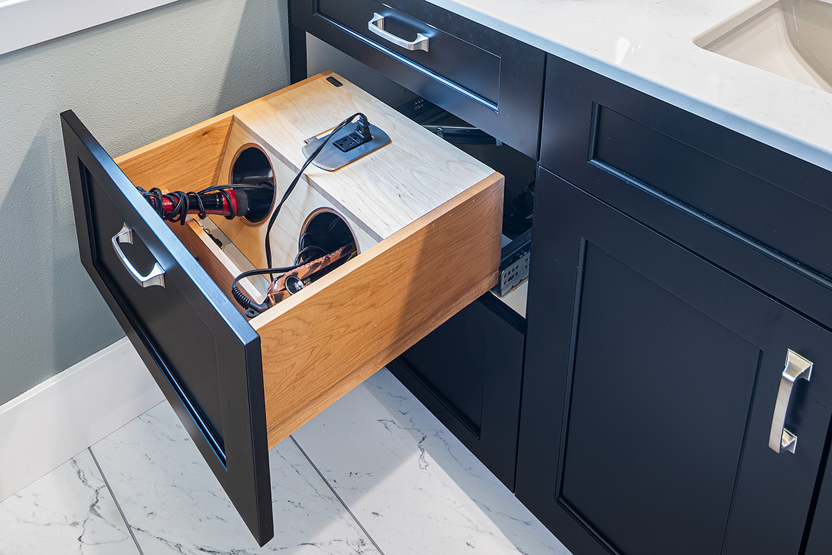 black bathroom cabinetry with curling iron and hair dryer specific drawer