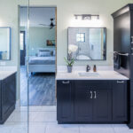 dual sink bathroom with black cabinets and white vanity