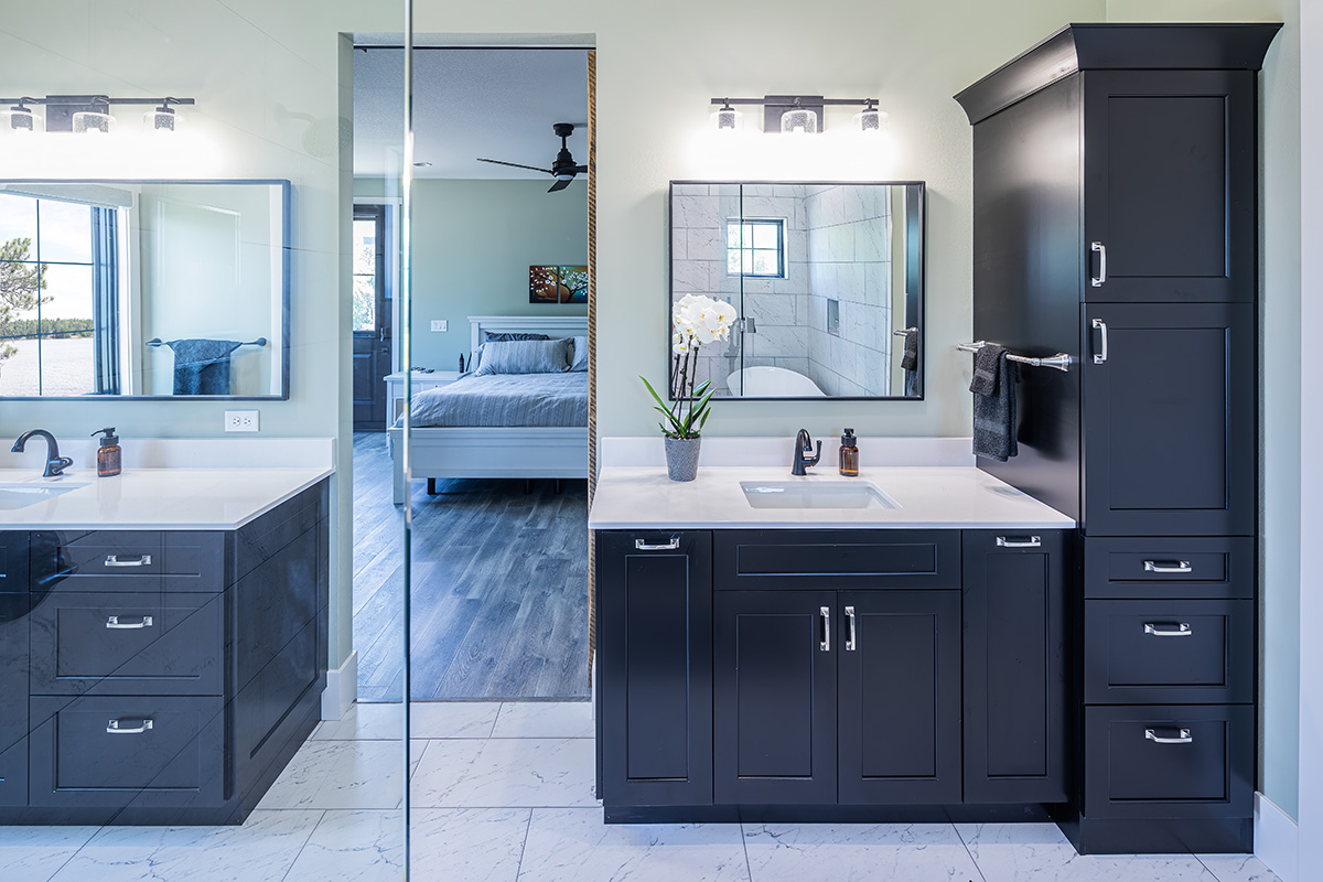 dual sink bathroom with black cabinets and white vanity