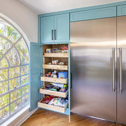 large fridge surrounded by turquoise cabinets, cabinets filled with snacks