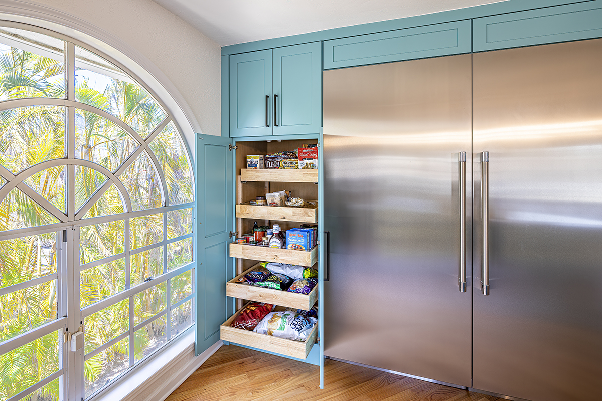 large fridge surrounded by turquoise cabinets, cabinets filled with snacks