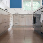 Stained kitchen perimeter with blue acrylic surface island cabinets