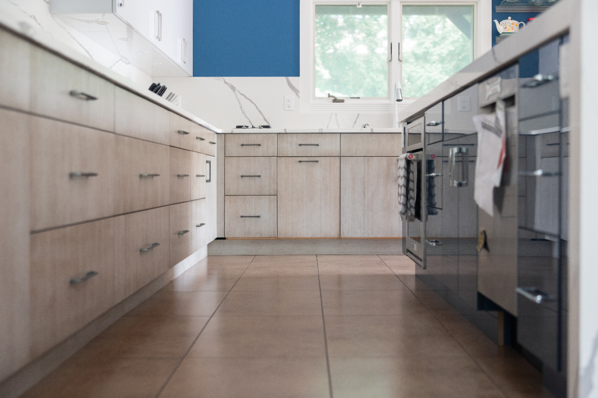 Stained kitchen perimeter with blue acrylic surface island cabinets