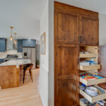 Blue painted kitchen with stained island and roll tray utility cabinet