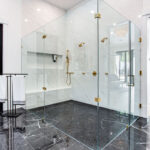 Large open glass shower looking into the master bedroom with reading area.