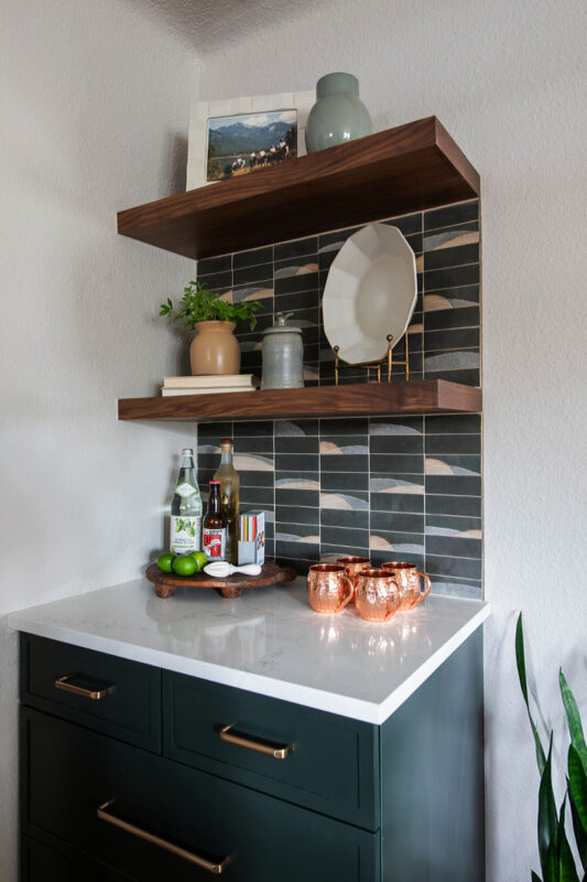 Painted cabinet and stained floating shelves as a small bar area