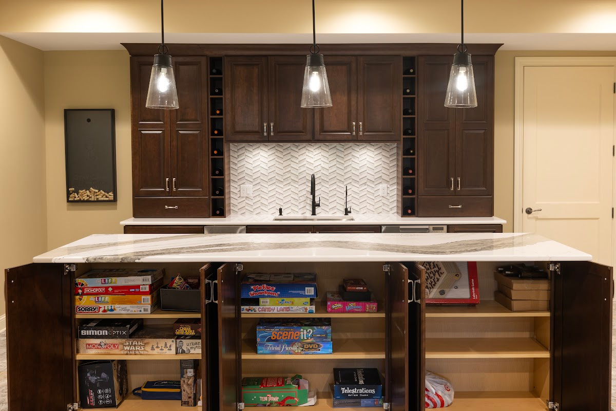 Stained home bar with island seating. Island storage doors are open to show shelves filled with games, etc.