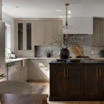 Light painted kitchen perimeter cabinets with stained island