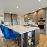 Stained kitchen and island cabinets with blue island chairs