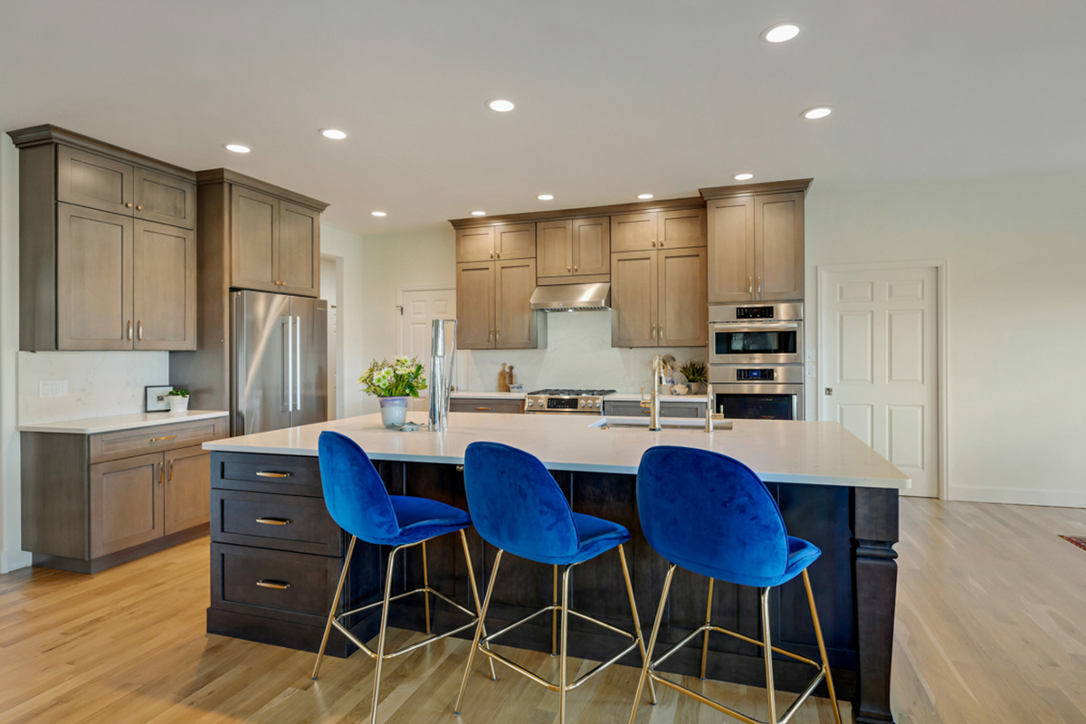 Stained kitchen and island cabinets with blue island chairs