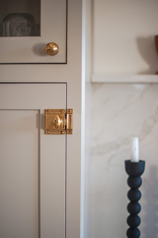 Painted cabinet. Image highlights a candle and gold cabinet hardware.