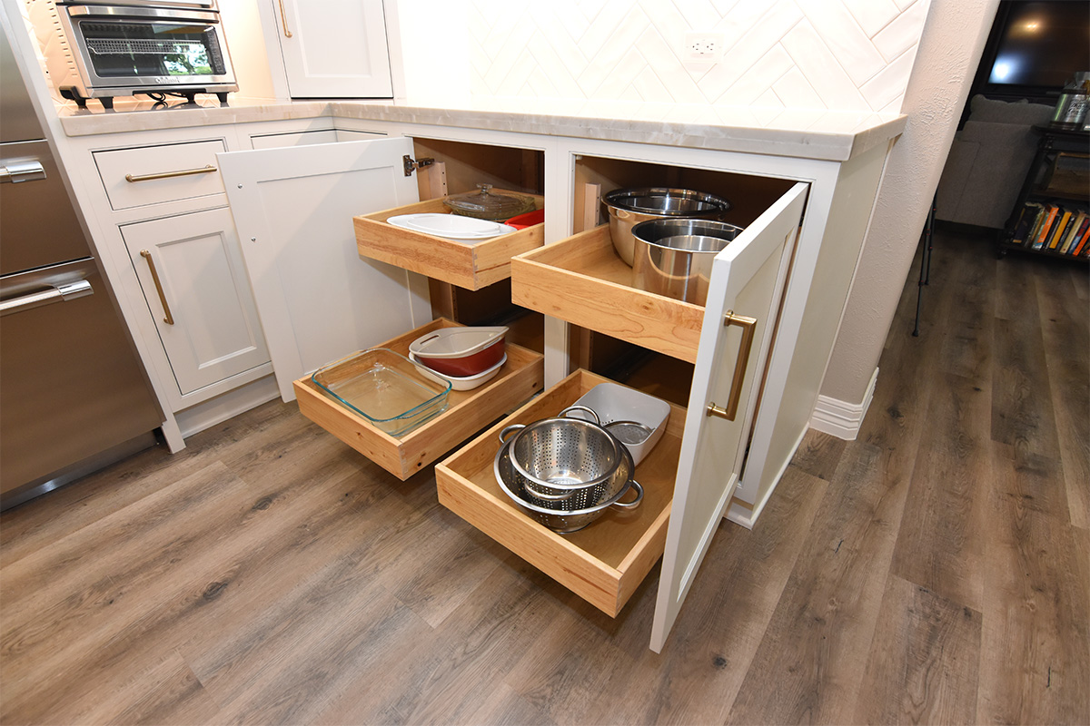 painted base cabinets with door open and roll trays pulled out