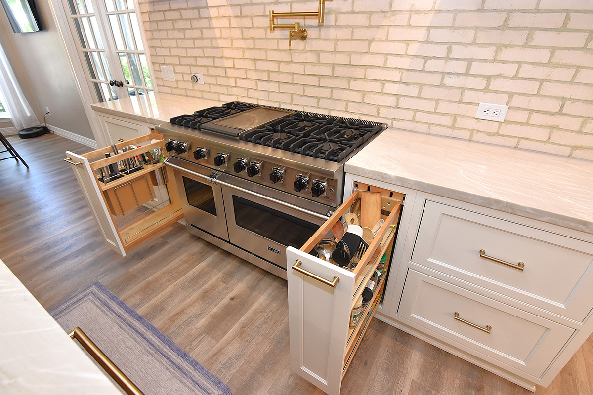 painted pullout storage cabinets pulled out on each side of a stove