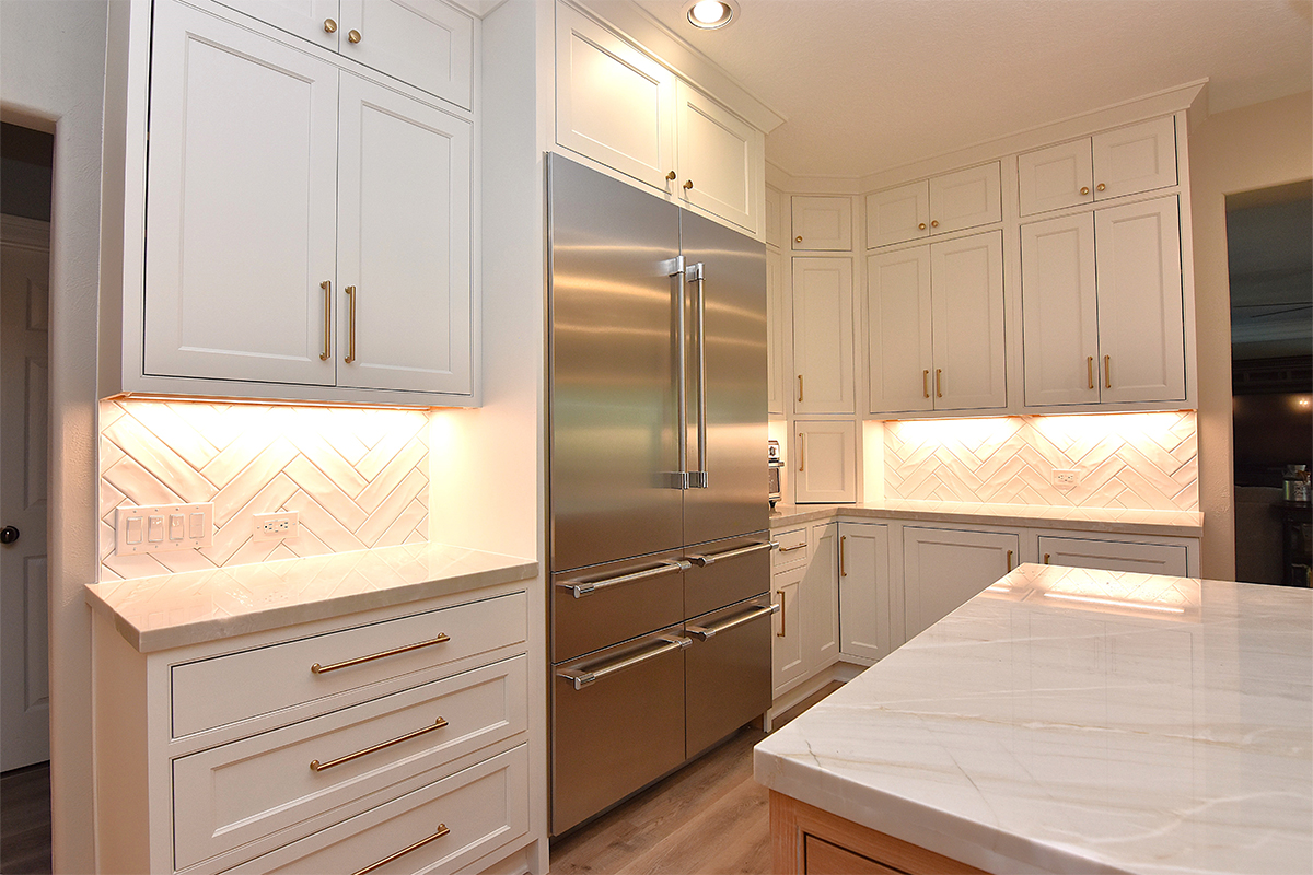 painted kitchen cabinets surrounding a large fridge