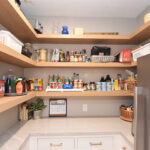 Pantry with stained floating shelves and painted cabinets below