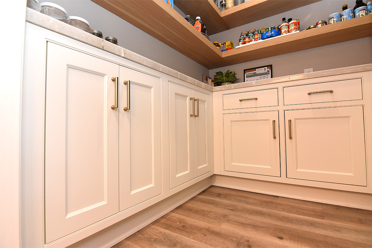 Pantry with stained floating shelves and painted cabinets below