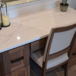 Stained bathroom vanity cabinets with open shelf on the bottom and a countertop wall cabinet splitting 2 sinks