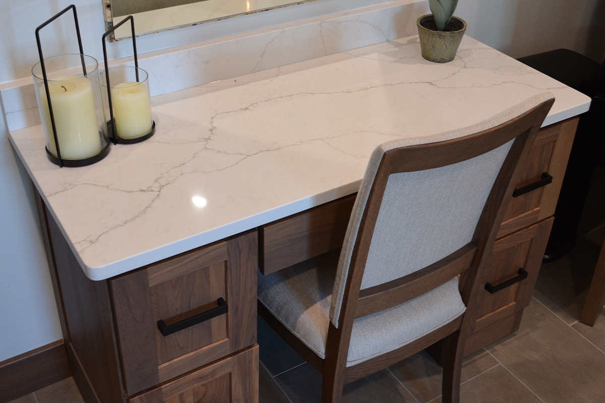 Stained bathroom vanity cabinets with open shelf on the bottom and a countertop wall cabinet splitting 2 sinks