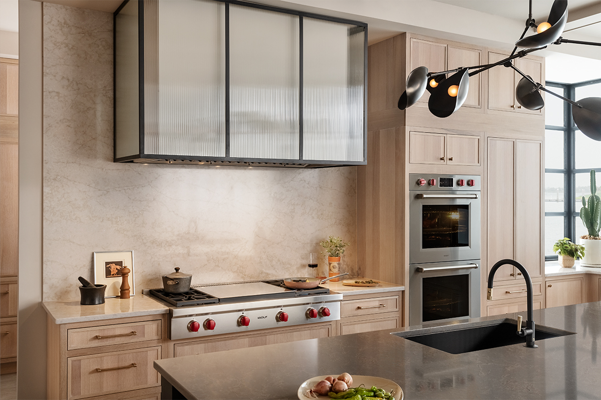 Stained kitchen and white hood with a glass casing over cooktop