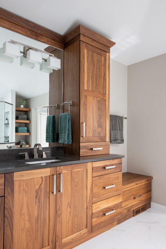 Walnut bathroom cabinets with 2 sinks and countertop storage on each end.