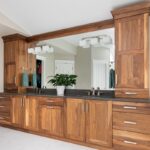 Walnut bathroom cabinets with 2 sinks and countertop storage on each end.