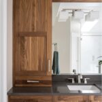 Walnut bathroom cabinets with 2 sinks and countertop storage on each end.