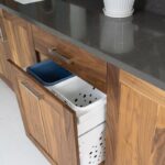 Walnut bathroom cabinets. Showing a hamper pullout.