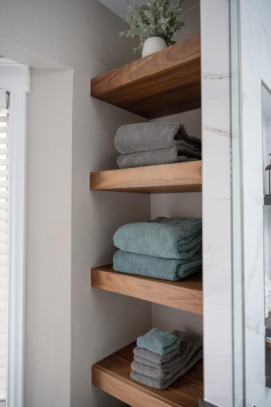 linen closet with stained shelves holding towels