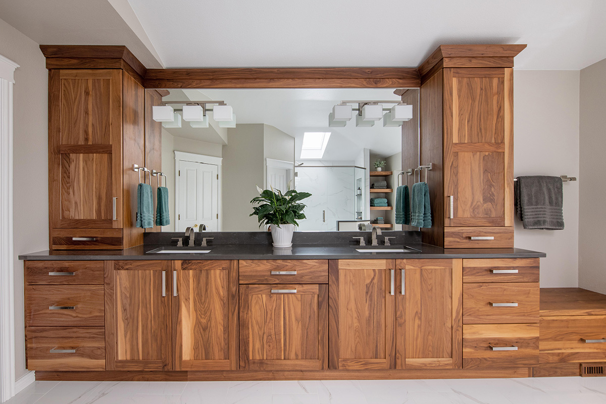 Walnut bathroom cabinets with 2 sinks and countertop storage on each end.