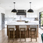 Kitchen with white painted perimeter cabinets and an island in quartersawn white oak with natural finish