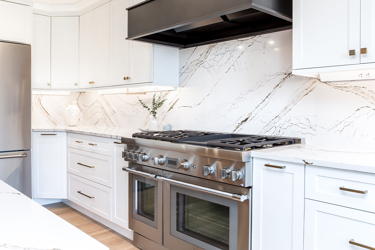 white kitchen cabinets with metal hood and stove