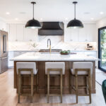 Kitchen with white painted perimeter cabinets and an island in quartersawn white oak with natural finish