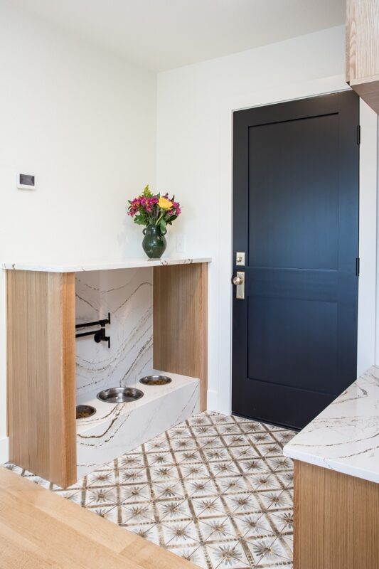 Mudroom cabinets with dog bowls encased in a doorless cabinet