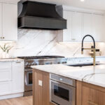 Kitchen with white painted perimeter cabinets and an island in quartersawn white oak with natural finish