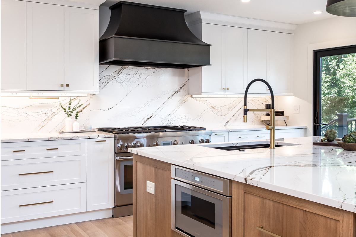Kitchen with white painted perimeter cabinets and an island in quartersawn white oak with natural finish