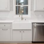 Painted kitchen sink cabinets next to a dishwasher