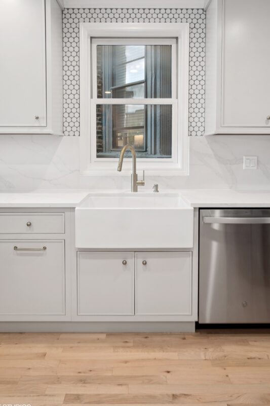 Painted kitchen sink cabinets next to a dishwasher