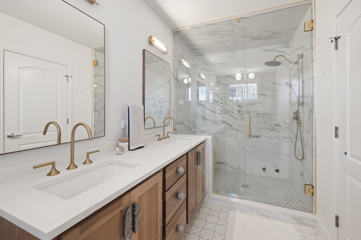 Stained bathroom vanity cabinet with glass wall shower