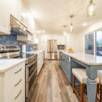 Kitchen with white perimeter cabinets and Smokey Blue island