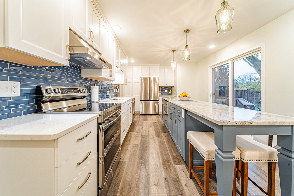 Kitchen with white perimeter cabinets and Smokey Blue island