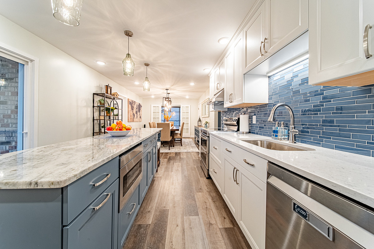 Kitchen with white perimeter cabinets and Smokey Blue island