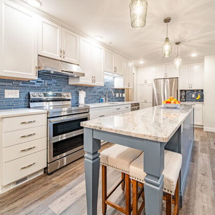 Kitchen with white perimeter cabinets and Smokey Blue island