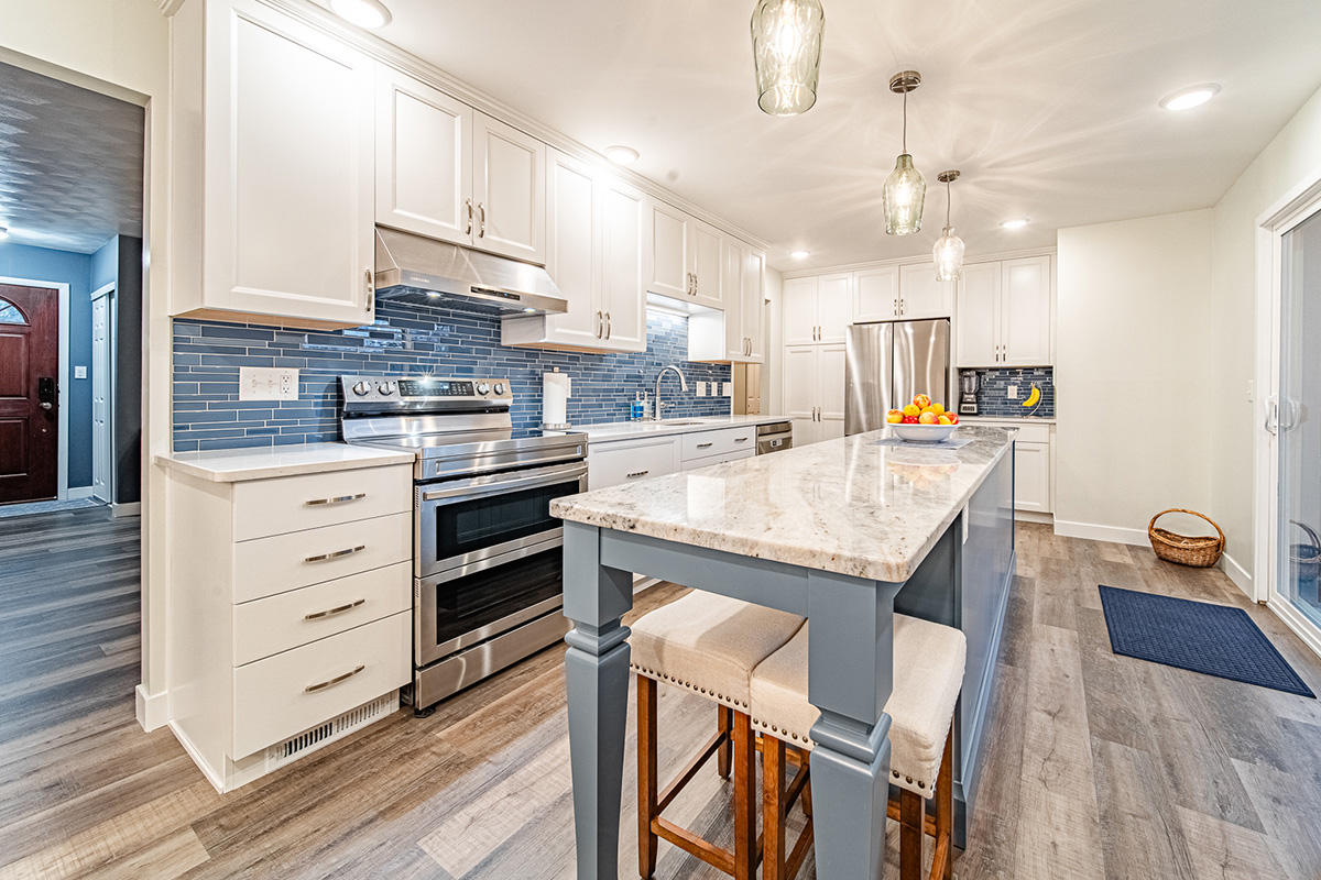Kitchen with white perimeter cabinets and Smokey Blue island