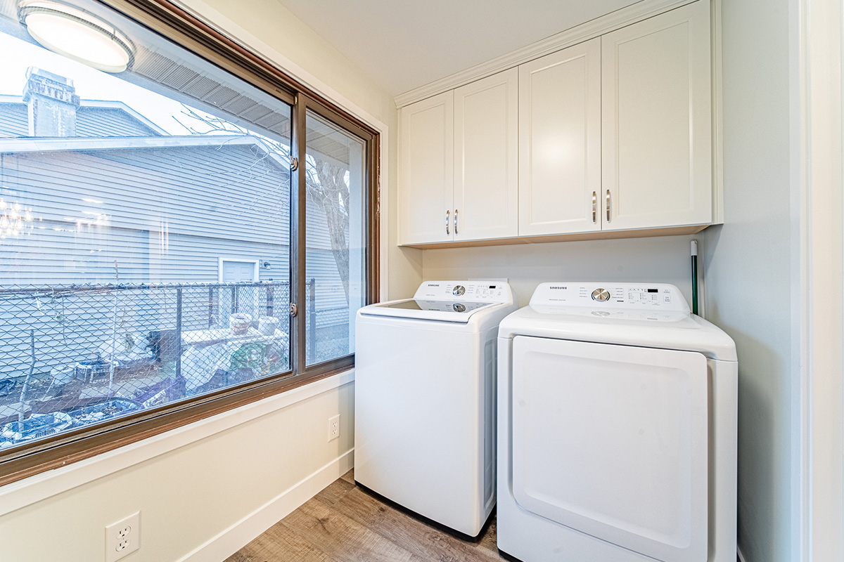 Laundry room with white cabinets and washer and dryer